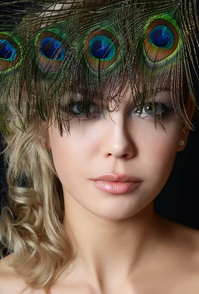 The beautiful woman with feathers of a peacock — Stock Photo, Image