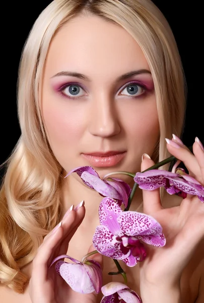 Η όμορφη νεαρή γυναίκα με λουλούδια ορχιδέας — Φωτογραφία Αρχείου