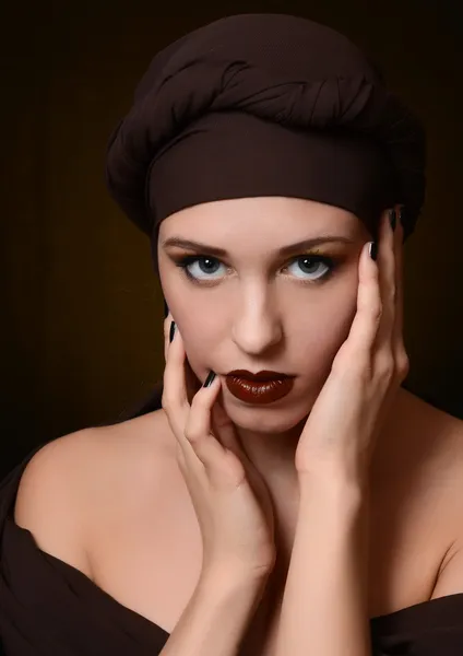 A bela mulher em um turbante com uma maquilagem criativa — Fotografia de Stock