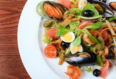 bir mürekkep balığı, ton balığı filetosu, midye et ile deniz ürünleri salatası