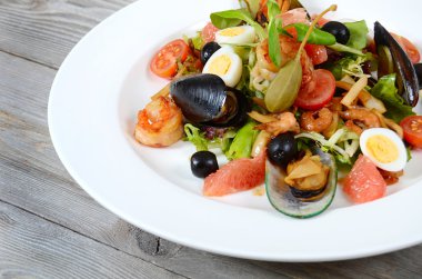 bir mürekkep balığı, ton balığı filetosu, midye et ile deniz ürünleri salatası