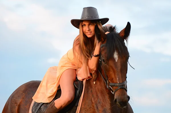 Kvinnan på en häst mot himlen — Stockfoto