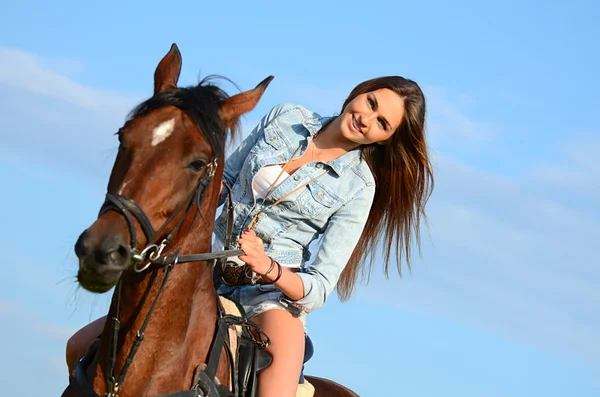 La mujer en un caballo contra el cielo — Foto de Stock