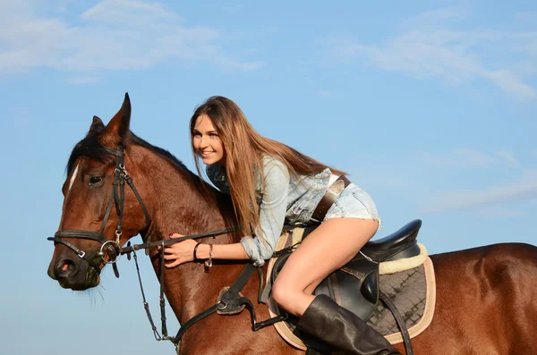 Kvinnan på en häst mot himlen — Stockfoto