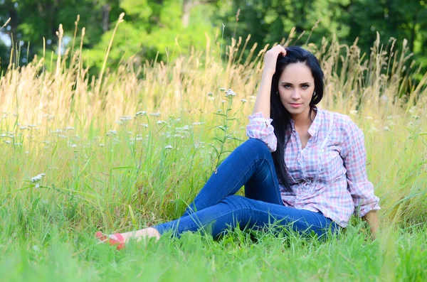 Piękna kobieta w pole z kwiatem — Zdjęcie stockowe