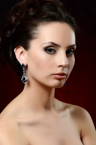 The beautiful woman in jewelry earrings — Stock Photo, Image