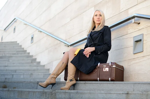 La belle femme avec une valise à un mur de briques — Photo