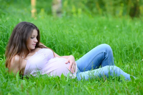 La donna incinta nell'estate su un'erba — Foto Stock