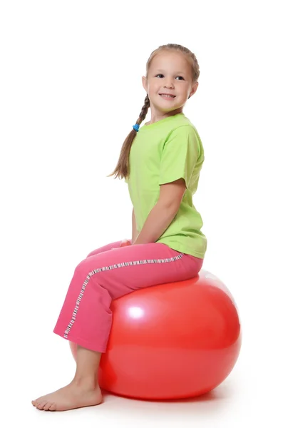 Liten flicka på en gymnastik boll — Stockfoto