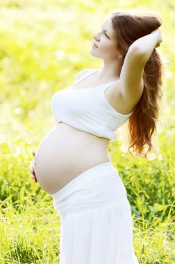 hamile kadın bir çimlerin üzerine yaz