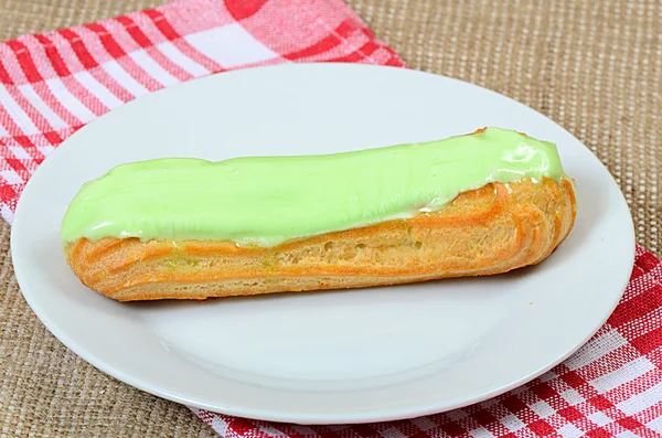 Eclair com uma nata em uma chapa — Fotografia de Stock