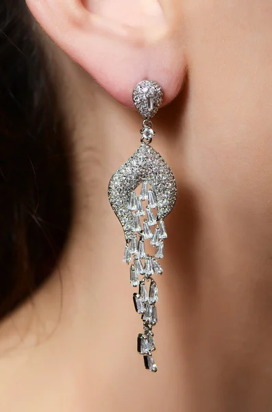 Female ear in jewelry earrings — Stock Photo, Image