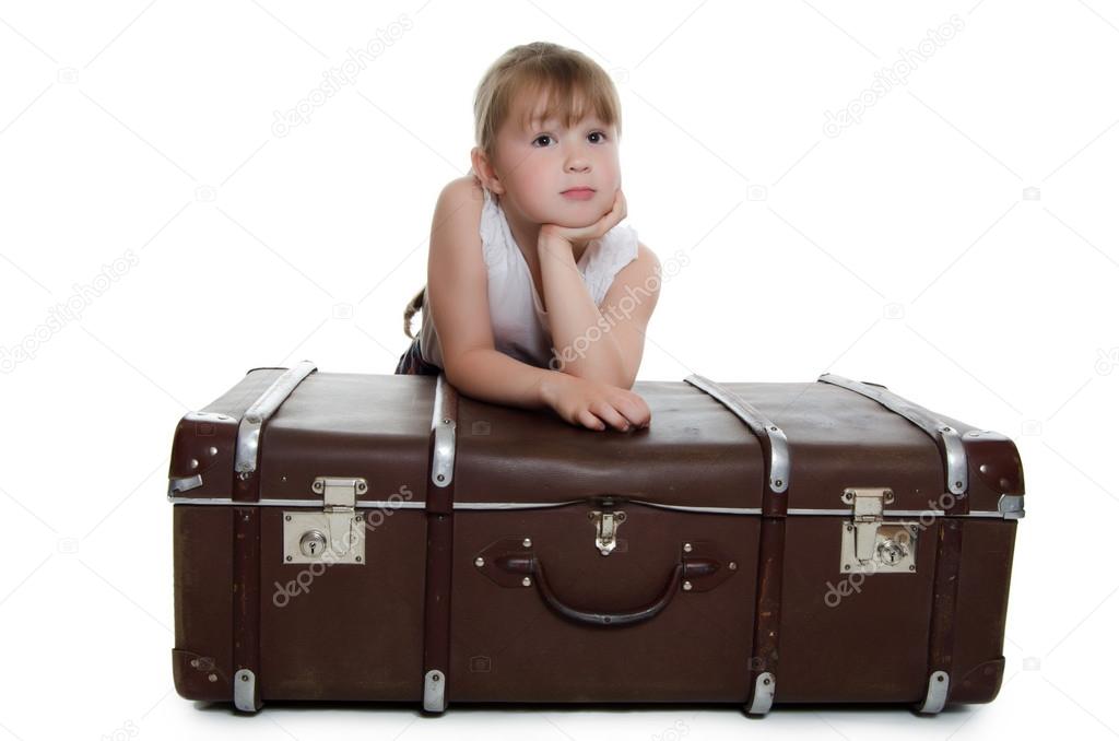 Little girl on old suitcases
