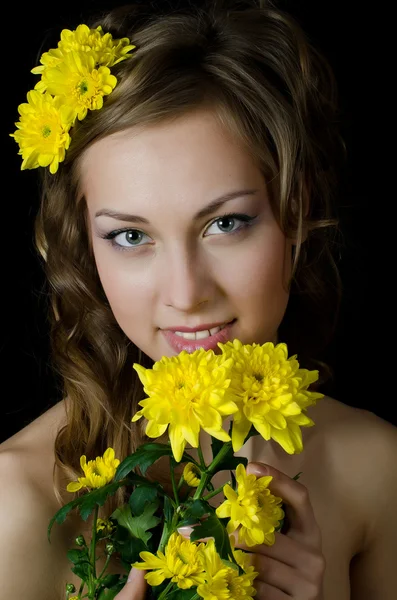 Дівчина з красивим волоссям з жовтою хризантемою — стокове фото