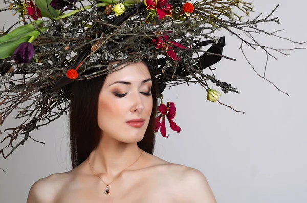 A gyönyörű lány a koszorú ágak és virágok — Stock Fotó