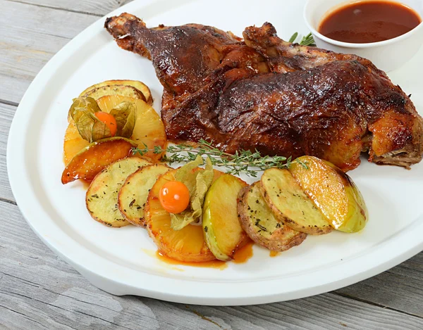 The baked half of duck with a potato, apples and pineapple — Stock Photo, Image