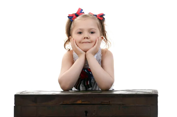 Hermosa joven modelo de niño sentado en un pecho —  Fotos de Stock