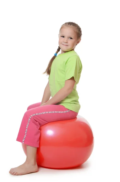Liten flicka på en gymnastik boll — Stockfoto