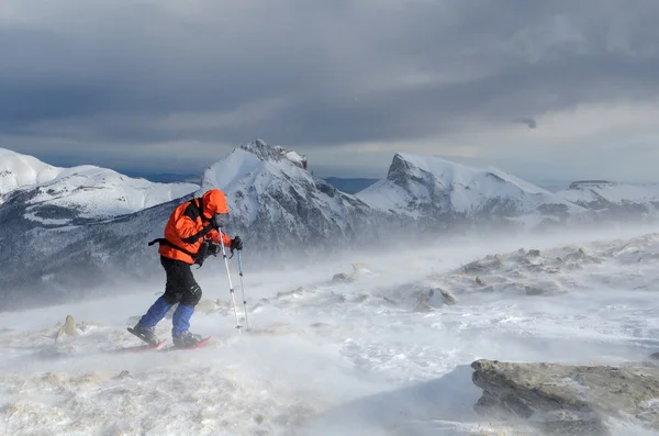 Um turista snowshoeing nas montanhas no inverno — Fotografia de Stock