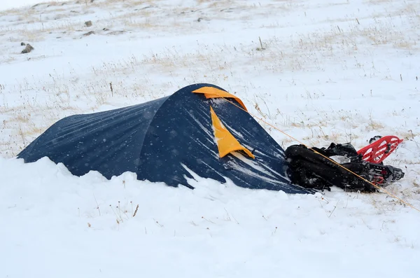Uma tenda e sapatos de neve cobertos de neve em uma caminhada de montanha extrema — Fotografia de Stock