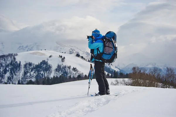 Een wandelaar overstag gaan foto met een camera in winter bergen — Stockfoto
