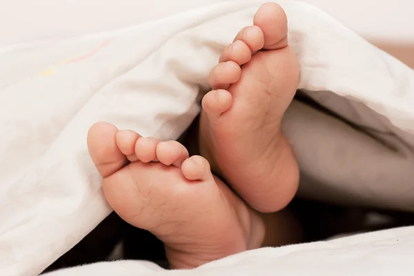 赤ちゃんの足が毛布の下 — ストック写真