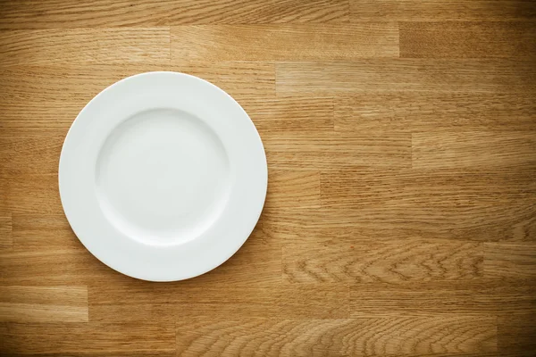 Порожня біла тарілка на дерев'яному столі — стокове фото