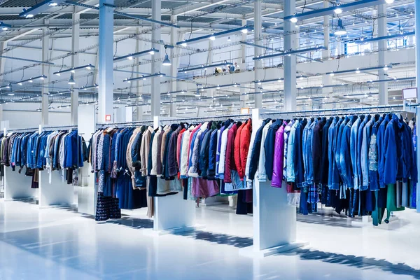 Big clothes outlet, luxury and fashionable interior of garments store. Coats department.