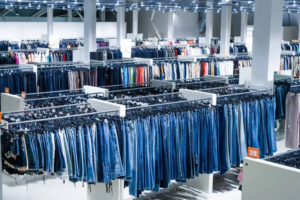 Big clothes outlet, luxury and fashionable interior of garments store. Jeans department.