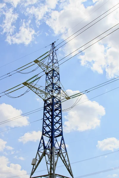 Eletricidade pilão contra o céu azul nublado — Fotografia de Stock