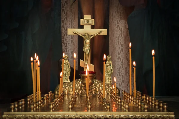 Kaarsen in de duisternis tegen het orthodoxe kruis — Stockfoto