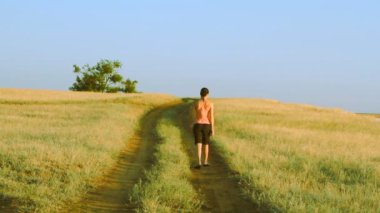 Kız boş kırsal yolda, çok uzaklara yaz günü yürüyüş