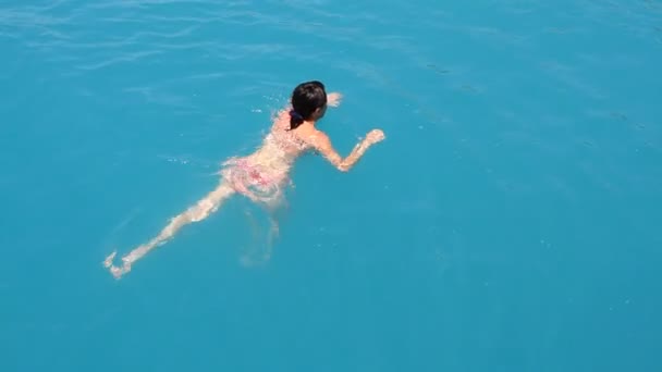 Junge Frau schwimmt im blauen Meer — Stockvideo