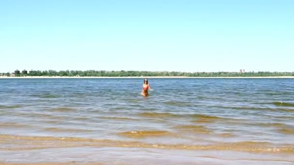 Gebräunte junge Frau läuft aus dem Meer — Stockvideo