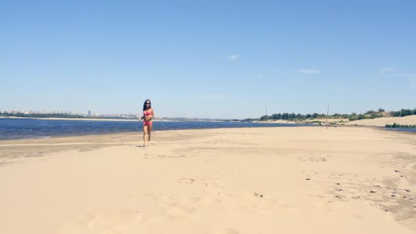 Gelooid jonge vrouw wordt uitgevoerd op het strand — Stockvideo