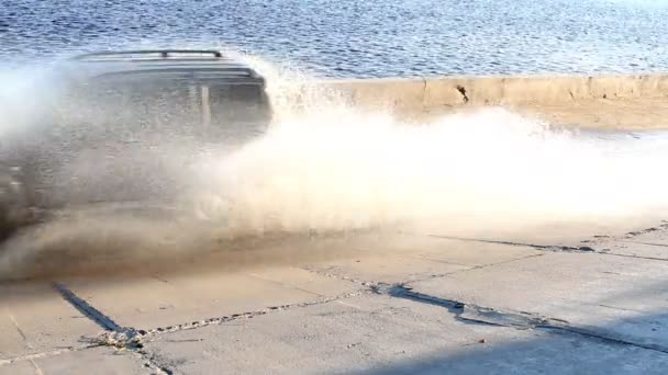 SUV οδηγεί μέσα από μια λακκούβα με ταχύτητα — Αρχείο Βίντεο