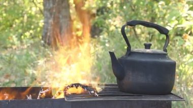 kamp ateşi üzerinde siyah eski füme çaydanlık