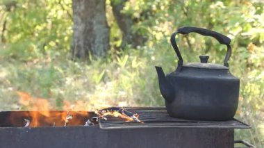 kamp ateşi üzerinde siyah eski füme çaydanlık