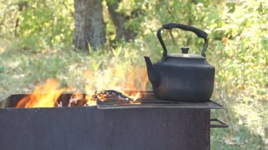 kamp ateşi üzerinde siyah eski füme çaydanlık