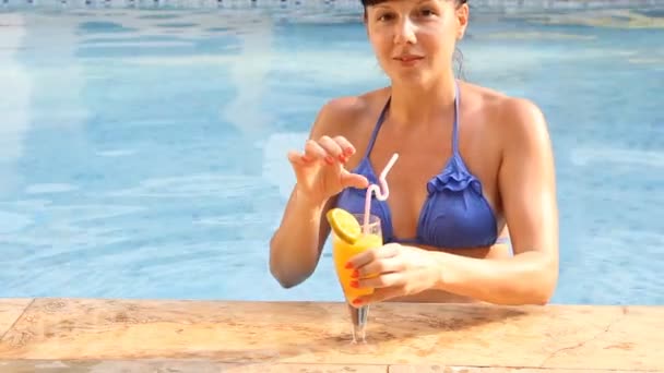 Beautiful woman relaxing in swimming pool with cocktails — Stock Video