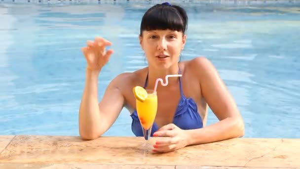 Όμορφη γυναίκα χαλαρώνοντας στην πισίνα με κοκτέιλ — Αρχείο Βίντεο