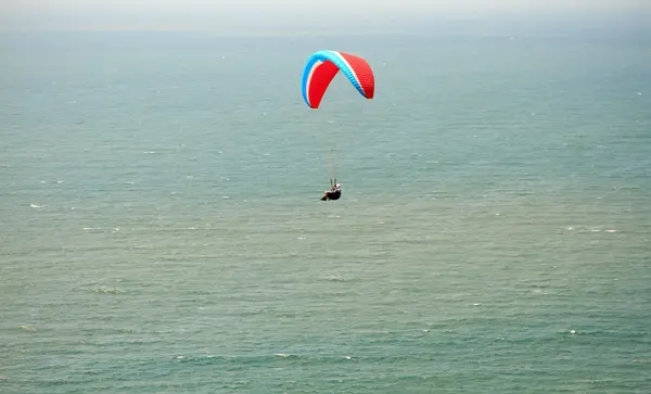 Fly i fallskjerm. Flyging med fly over havet – stockfoto
