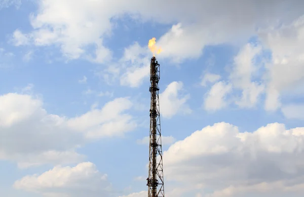 Raffinerie brennt Gasfackel über bewölktem Himmel — Stockfoto