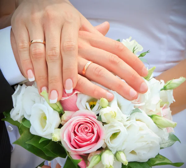 Χέρια και δαχτυλίδια σε γαμήλια ανθοδέσμη — Φωτογραφία Αρχείου