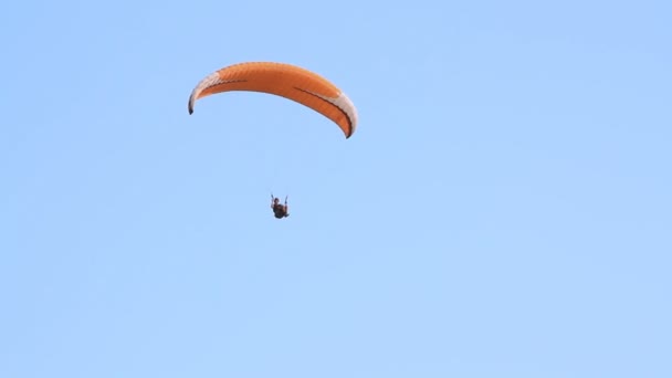 Yamaç paraşütü karşı dağlar üzerine açık mavi gökyüzü — Stok video