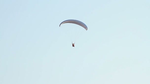 Parapente sobre las montañas contra el cielo azul claro — Vídeos de Stock