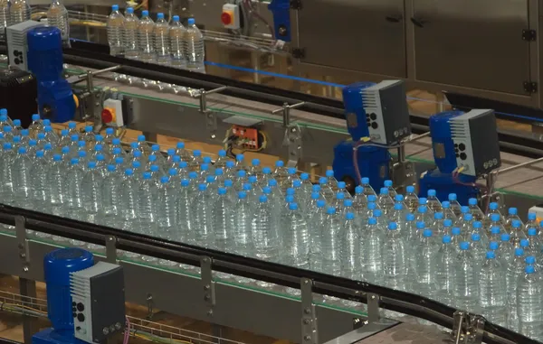 Bottiglie di acqua di plastica sul trasportatore e acqua imbottigliatrice ind — Foto Stock