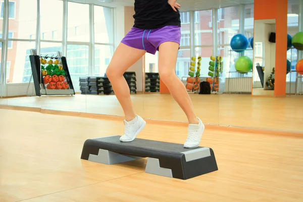 Mooie vrouwelijke benen op het bord stap tijdens oefening — Stockfoto