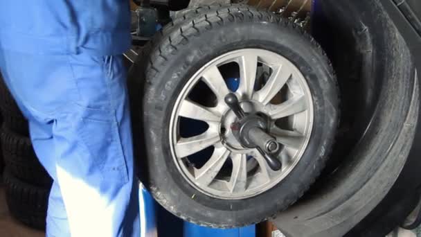 Reparador mecánico que hace equilibrio de la rueda en la máquina herramienta — Vídeo de stock