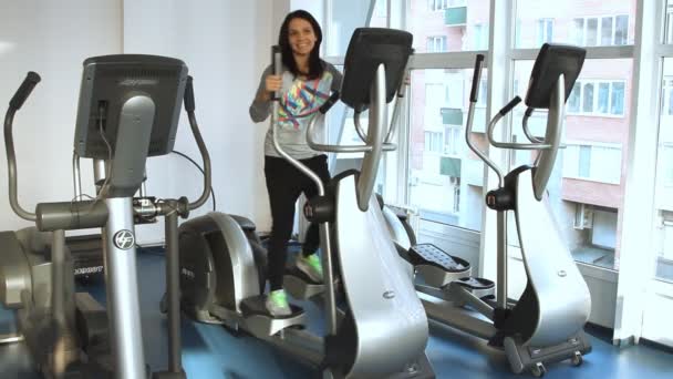 Junge Frau turnt auf einem Crosstrainer — Stockvideo